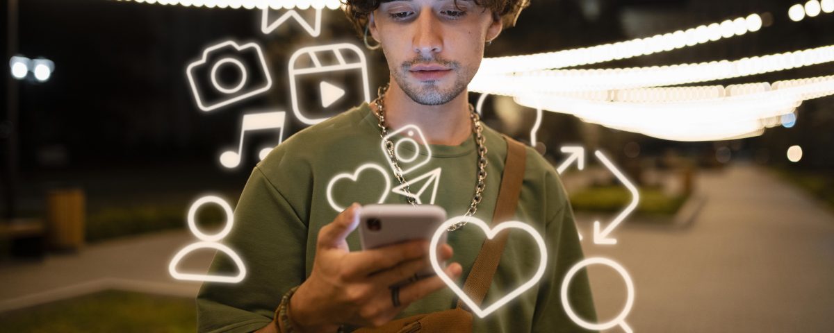 Un pequeño empresario sonriente usando su móvil para publicar en redes, con iconos de Instagram y Facebook flotando.